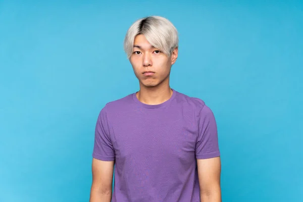 Joven Asiático Hombre Sobre Aislado Azul Fondo Con Triste Deprimido — Foto de Stock
