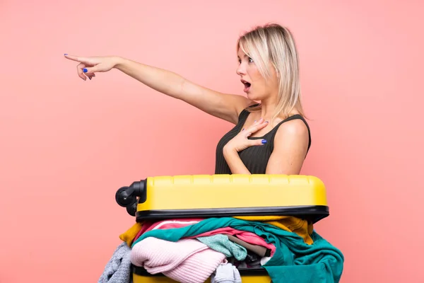 Traveler Woman Suitcase Full Clothes Isolated Pink Background Pointing Finger — Stock Photo, Image