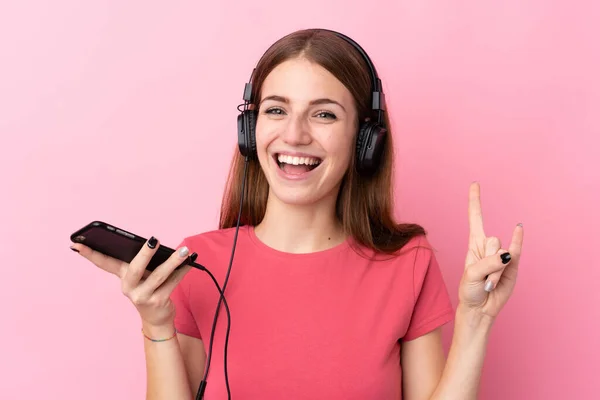 Giovane Donna Sfondo Rosa Isolato Ascoltare Musica Con Cellulare Facendo — Foto Stock