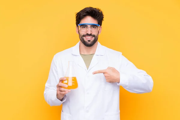 Joven Científico Sobre Fondo Amarillo Aislado Señalándolo — Foto de Stock