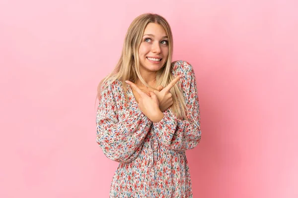 Jeune Femme Blonde Isolée Sur Fond Rose Pointant Vers Les — Photo