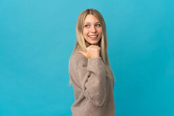 Jeune Femme Blonde Isolée Sur Fond Bleu Pointant Vers Côté — Photo