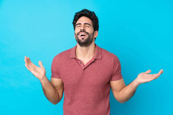 Joven Hombre Guapo Con Barba Sobre Fondo Azul Aislado Sonriendo —  Fotos de Stock