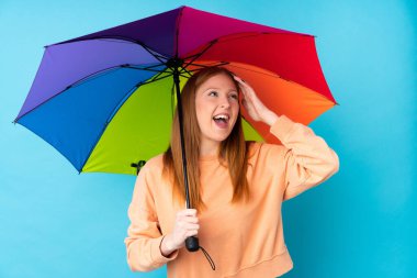 Duvarın üzerinde şemsiye tutan genç kızıl saçlı kadın bir şey fark etti ve çözüme niyetlendi.