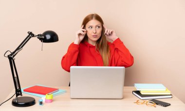 İş yerinde dizüstü bilgisayarı olan genç bir kız öğrencinin şüpheleri ve düşünceleri var.