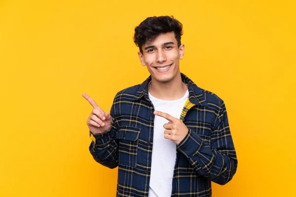 Young Argentinian Man Isolated Yellow Background Pointing Finger Side — Stock Photo, Image