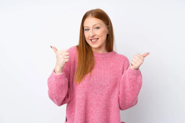 年轻的红头发女人 穿着粉色毛衣 背对孤立的白色背景 竖起大拇指 微笑着 — 图库照片