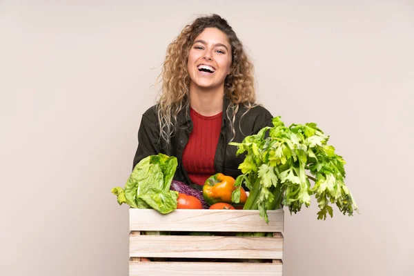 Rolnik Świeżo Zebranymi Warzywami Pudełku Odizolowanym Beżowym Tle Śmieje Się — Zdjęcie stockowe