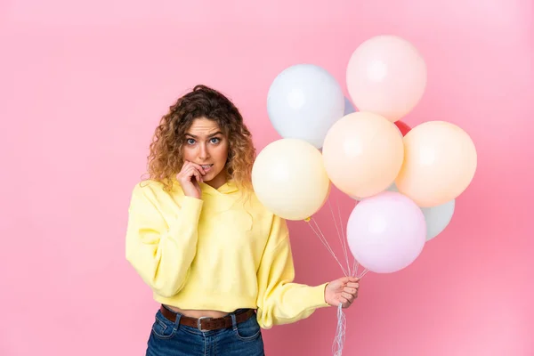 Mujer Rubia Joven Con Pelo Rizado Captura Muchos Globos Aislados — Foto de Stock