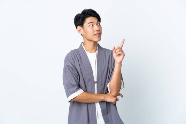 Beyaz arka planda izole edilmiş genç bir Çinli harika bir fikre işaret ediyor.