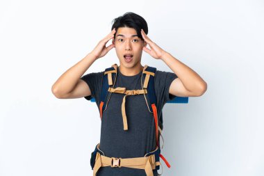 Dağcı Çinli adam beyaz arka planda yalnız ve sürpriz bir ifadeyle