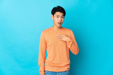 Mavi arka planda izole edilmiş genç bir Çinli kendini işaret ediyor.