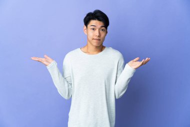 Mor arka planda izole edilmiş genç bir Çinli el kaldırırken şüpheleri var.