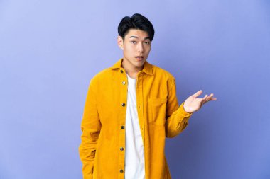 Mor arka planda izole edilmiş genç bir Çinli şüpheli hareketler yapıyor.