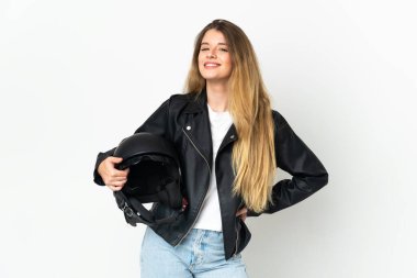 Beyaz arka planda izole edilmiş motosiklet kaskı tutan kadın kolları kalçasında ve gülümsüyor.