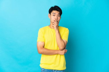 Mavi arka planda mahsur kalmış genç bir Çinli sağa bakarken şaşırmış ve şok olmuştu.