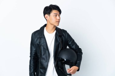 Beyaz arka planda izole edilmiş motosiklet kasklı Çinli bir adam yan tarafa bakıyor.