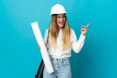 Miğferli ve elinde mavi arka planda izole edilmiş planları olan genç mimar kadın çözümü fark ederken parmağını kaldırmayı amaçlıyor.