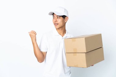 Çinli adam beyaz arka planda izole edilmiş bir şekilde bir ürün sunmak için kenarı işaret ediyor.