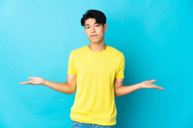 Mavi arka planda mahsur kalmış genç Çinli adamın şüpheleri var.