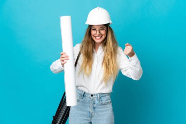 Kasklı ve elinde mavi arka planda izole edilmiş planları olan genç mimar kadın galibiyeti kutluyor.