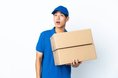 Çinli adam beyaz arka planda izole edilmiş yukarı bakıyor ve şaşırmış bir ifadeyle