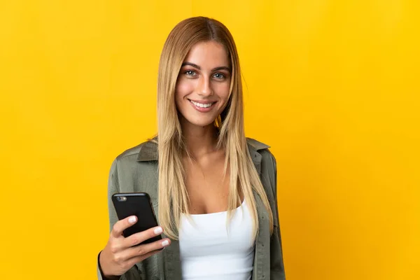 Mujer Rubia Joven Aislada Sobre Fondo Amarillo Usando Teléfono Móvil — Foto de Stock