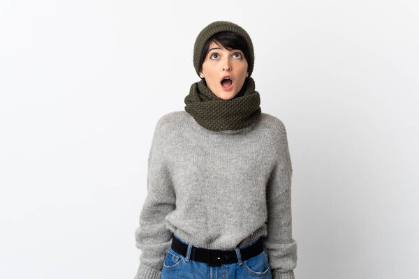 Young girl with winter hat looking up and with surprised expression