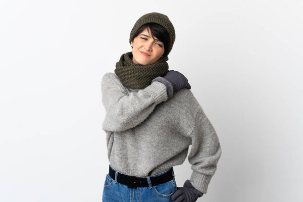 Young girl with winter hat suffering from pain in shoulder for having made an effort