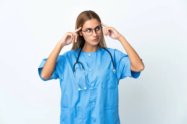 外科医の女性の上に隔離された白い背景疑問と思考を持っている — ストック写真