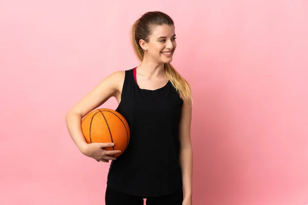 Joven Mujer Rubia Jugando Baloncesto Aislado Sobre Fondo Rosa Mirando —  Fotos de Stock