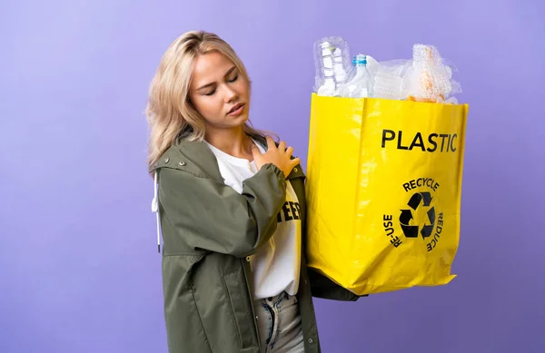 肩の痛みに苦しむ紫色の背景に隔離されたリサイクル紙の袋を持っている若いロシアの女性は 努力をした — ストック写真