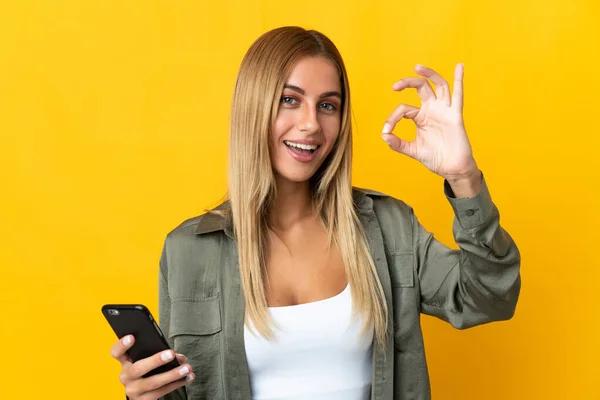 Mujer Rubia Joven Aislada Sobre Fondo Amarillo Utilizando Teléfono Móvil — Foto de Stock