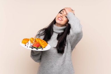 Tecrit edilmiş arka planda waffle tutan genç Kolombiyalı kız bir şey fark etti ve çözüme niyetlendi.