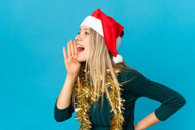 Mavi arka planda izole edilmiş, ağzı sonuna kadar açık bağıran bir kadın.