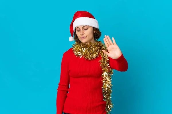 英語の女の子とともにクリスマス帽子隔離上の青背景作るストップジェスチャーと失望 — ストック写真