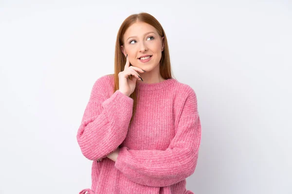 年轻的红头发女人 穿着粉色毛衣 背负着孤立的白色背景 抬起头来想办法 — 图库照片
