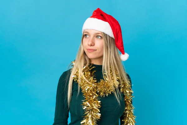 Mujer Con Sombrero Navidad Aislado Sobre Fondo Azul Mirando Lado —  Fotos de Stock