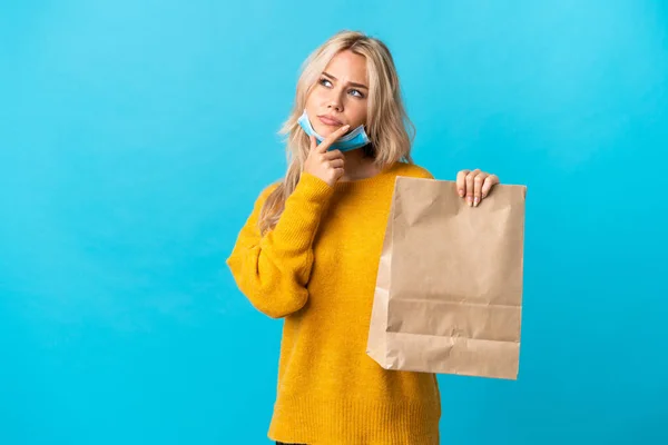 Junge Russin Mit Einkaufstasche Auf Blauem Hintergrund Hat Zweifel — Stockfoto