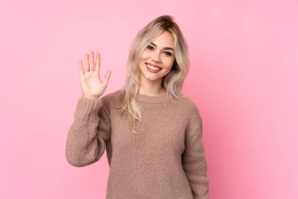 스웨터 소녀가 분홍색 배경에서 손으로 표정으로 경례를 — 스톡 사진