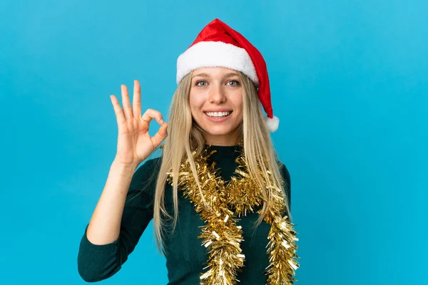 Mujer Con Sombrero Navidad Aislado Sobre Fondo Azul Mostrando Signo —  Fotos de Stock