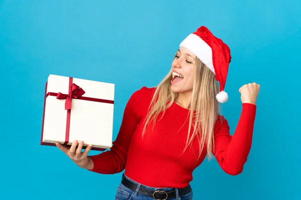 Kvinna Med Jul Hatt Håller Present Isolerad Blå Bakgrund Firar — Stockfoto