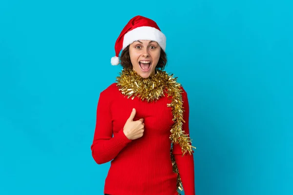 英国姑娘戴着一顶蓝色背景的圣诞帽 脸上带着惊讶的表情 — 图库照片
