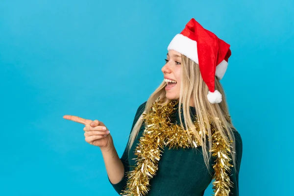 Kvinna Med Jul Hatt Isolerad Blå Bakgrund Peka Finger Sidan — Stockfoto