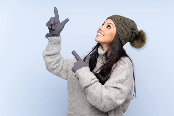 Jovem Colombiana Com Chapéu Inverno Sobre Fundo Azul Isolado Apontando — Fotografia de Stock