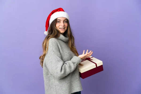 女の子とともにクリスマス帽子保持していますプレゼント隔離された上にホワイトバックカウント5とともに指 — ストック写真