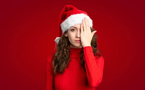 女の子とともにクリスマス帽子以上隔離された赤の背景 — ストック写真