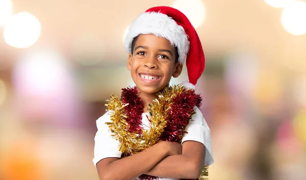 在模糊的背景下 戴着圣诞礼帽的非裔美国男孩面带微笑 — 图库照片