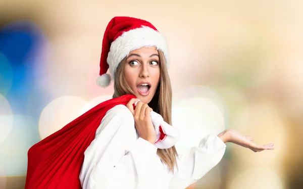 Молодая Блондинка Подбирает Сумку Полную Подарков Рождественских Праздниках Несобранном Фоне — стоковое фото