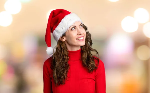 Zole Edilmiş Kırmızı Arka Planda Noel Şapkası Takan Kız — Stok fotoğraf